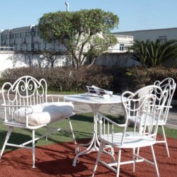 Luxurious iron table and chairs with wrought iron armrests sleek and elegant retro garden benches