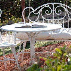 Luxurious iron table and chairs with wrought iron armrests sleek and elegant retro garden benches